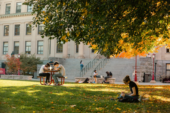Students enjoying nice weather on faculty building lawn 