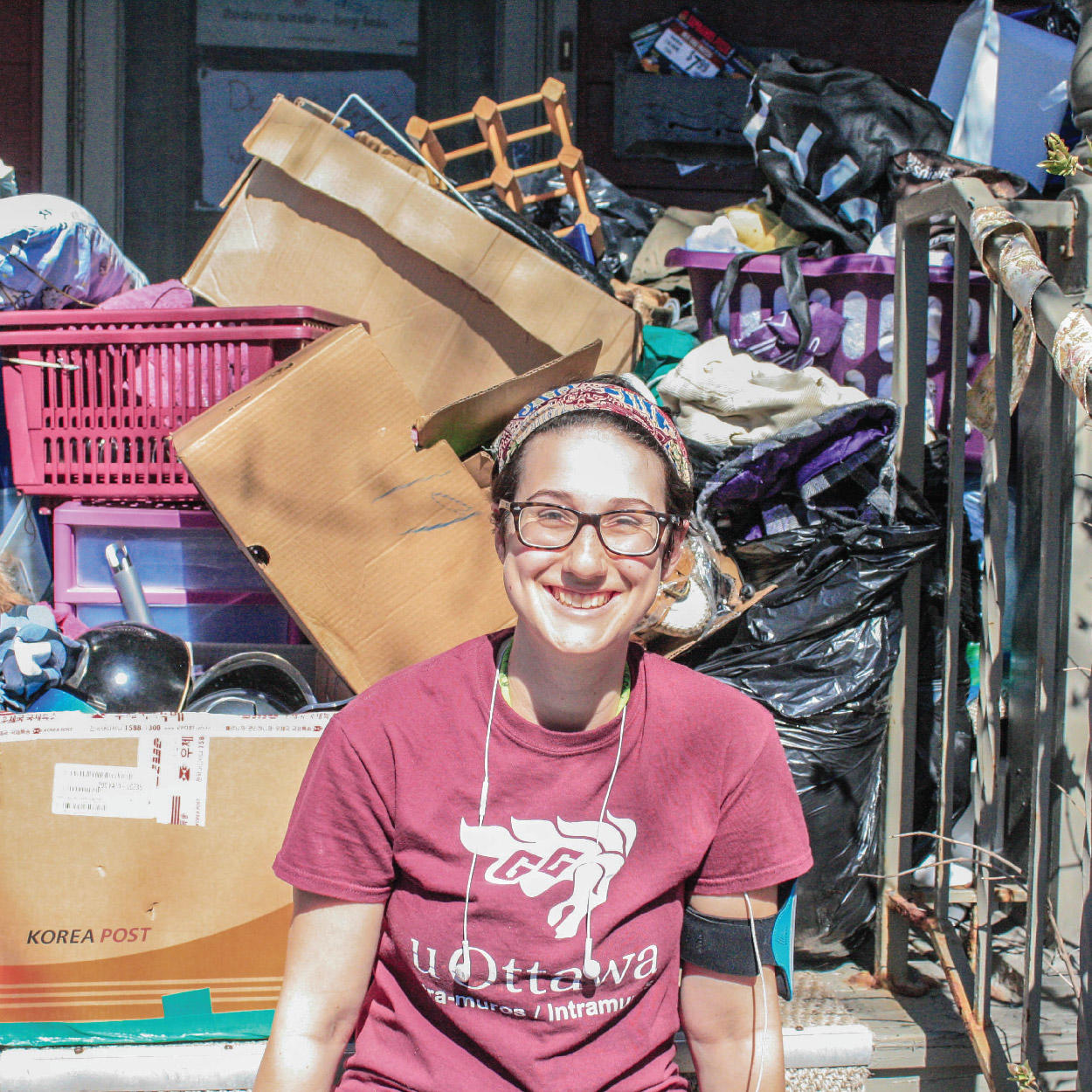Student in front of a porch loaded with donations for the Dump and Run