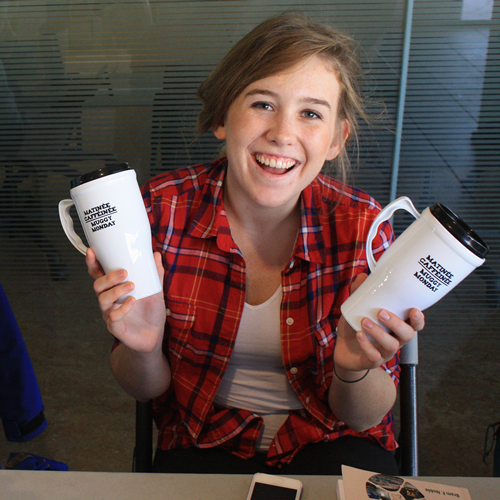Student holding reusable mugs
