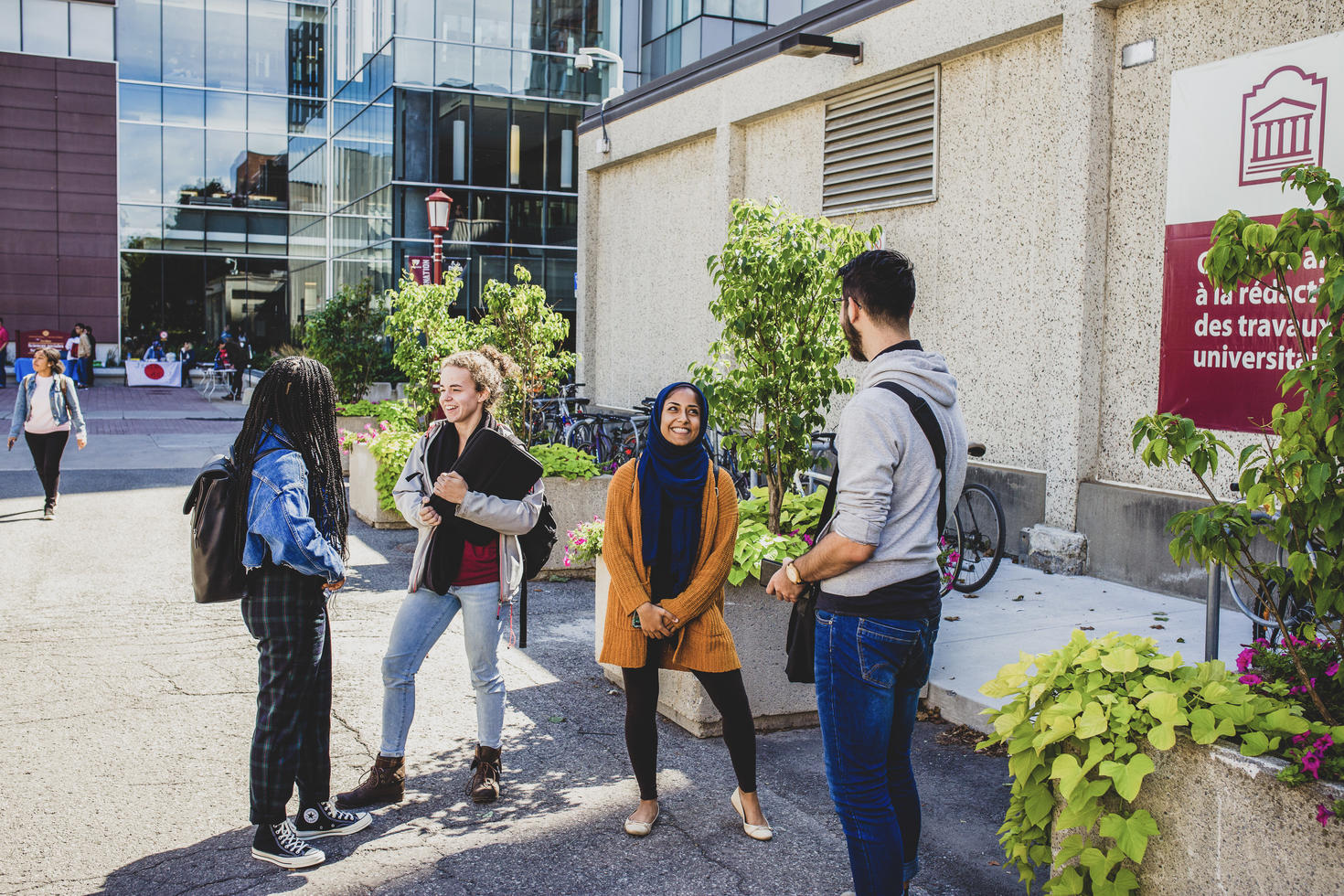 Group of four students having a conversation outdoors on campus