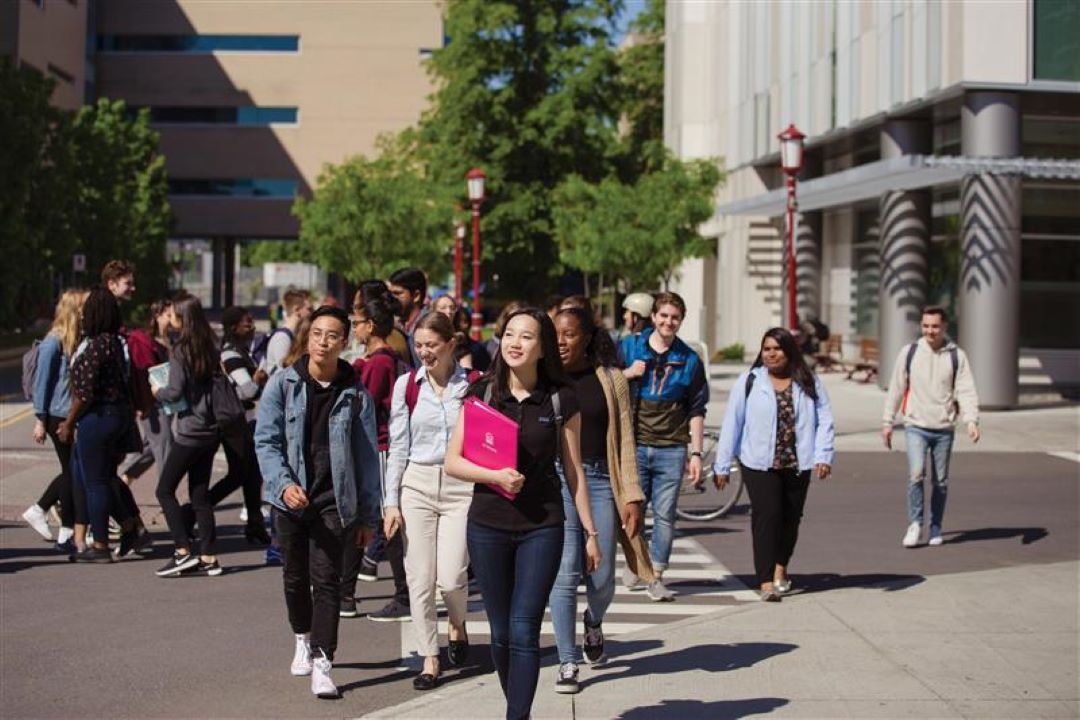 Une foule d'étudiants marche à l'extérieur sur le campus.