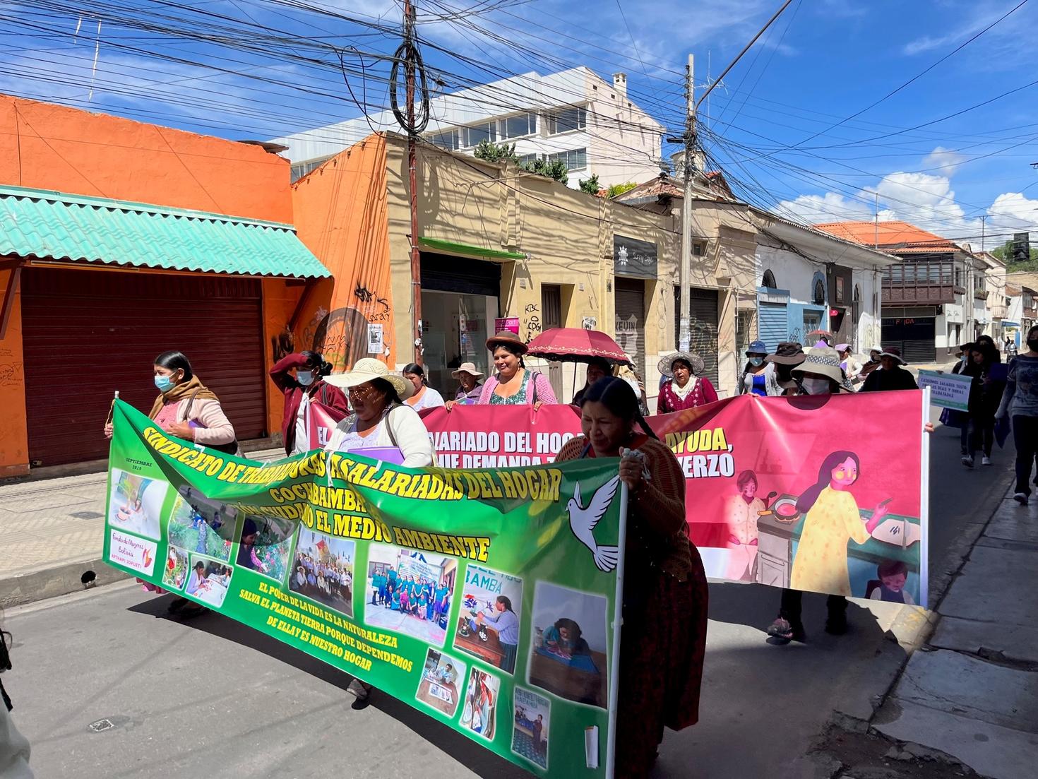 femmes boliviennes marchant dans la rue en tenant des banderoles