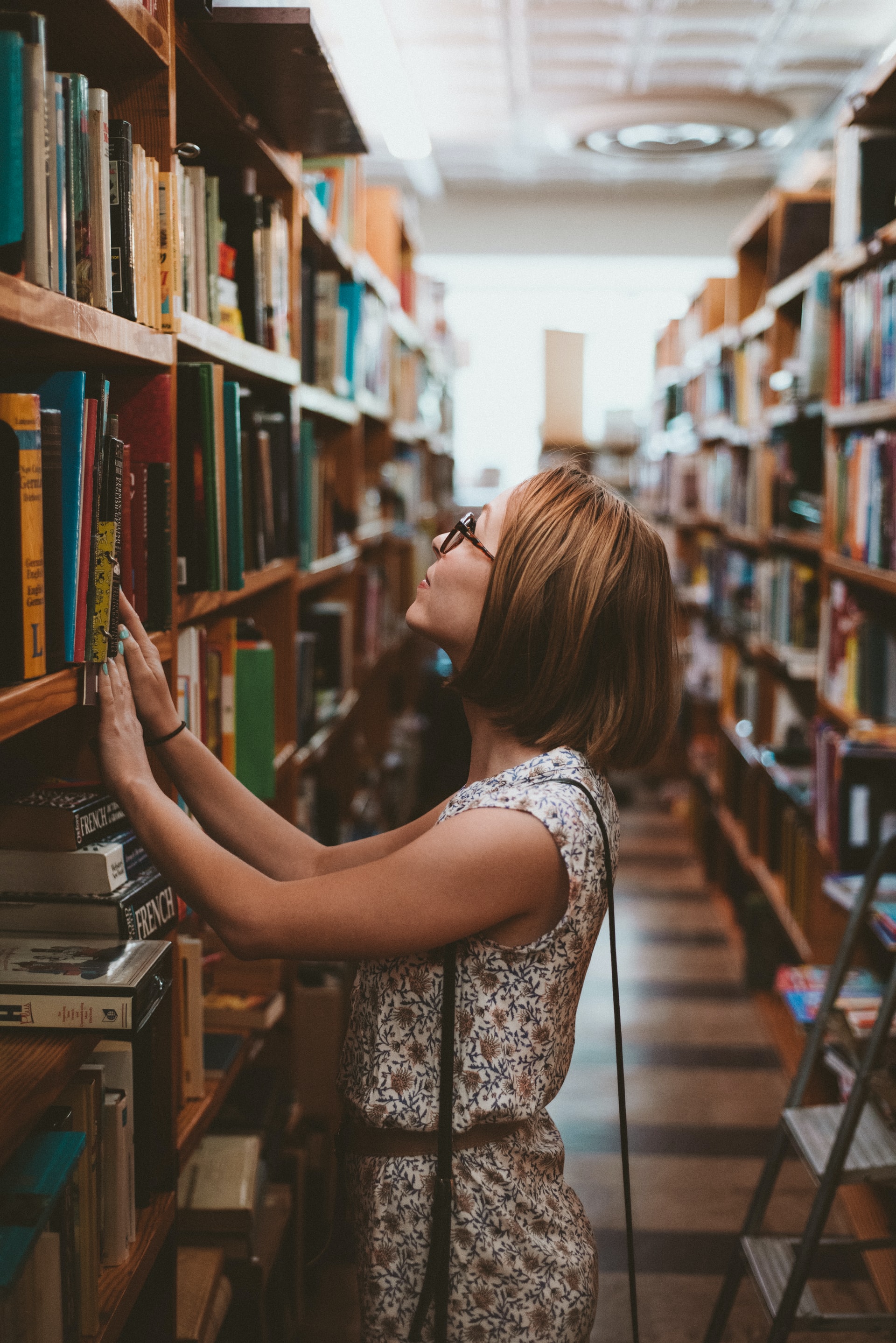  Femme regardant des livres dans une bibliothèque 