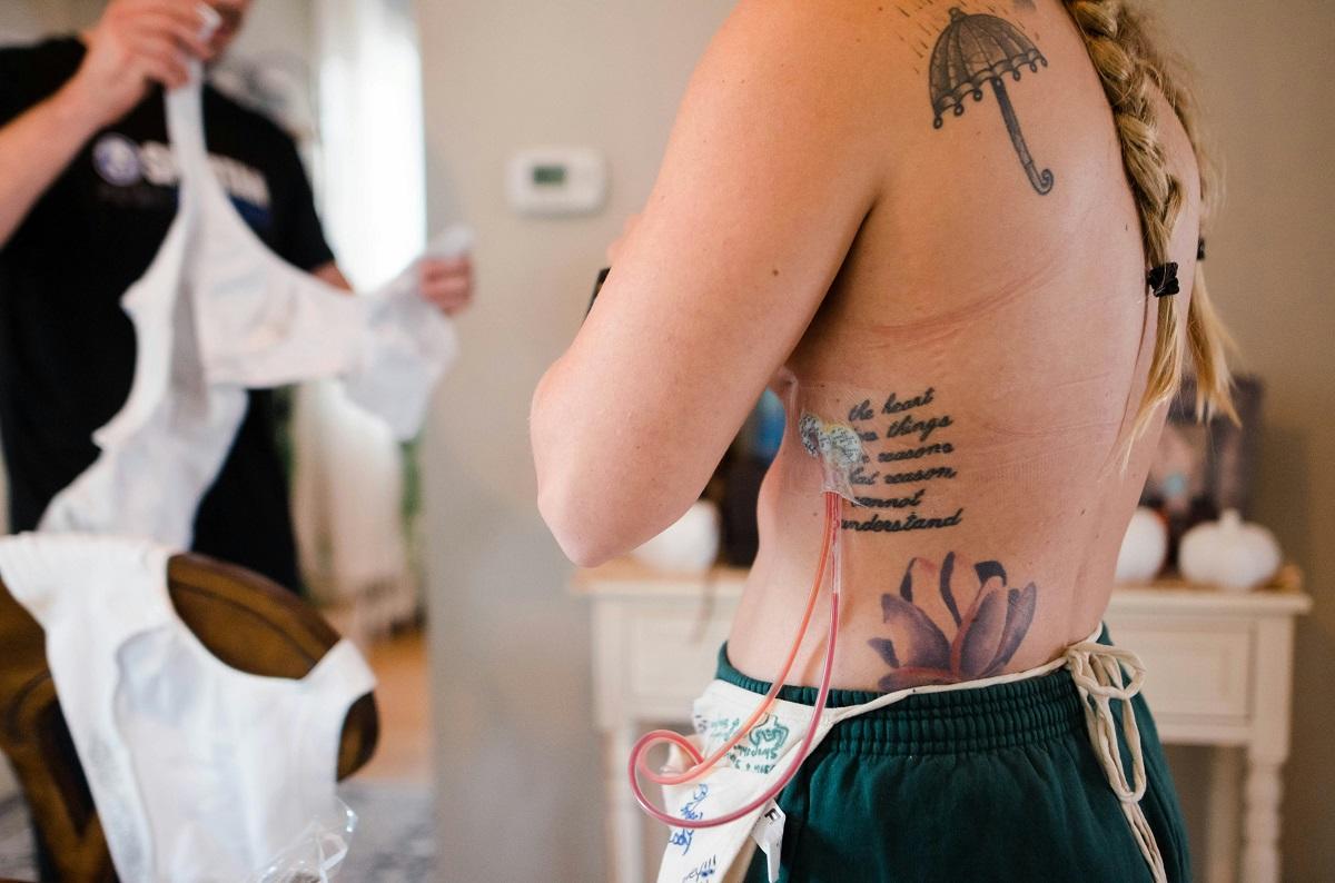 Femme tatouée ayant subi une opération du cancer du sein et essayant un soutien-gorge