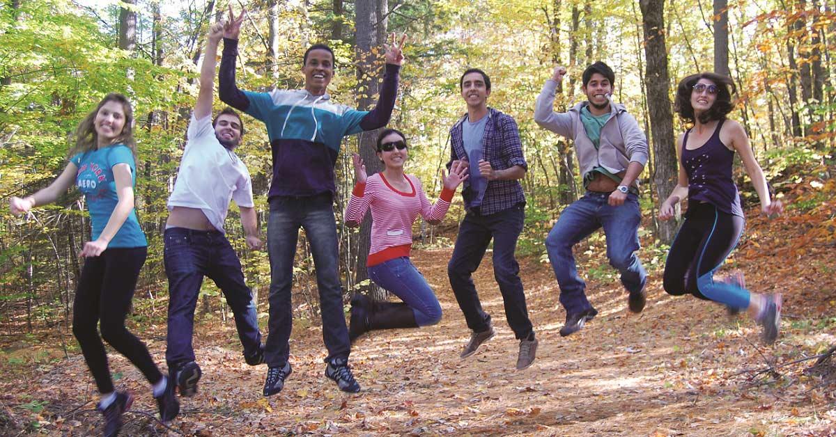 Étudiants internationaux qui sautent ensemble dans la forêt