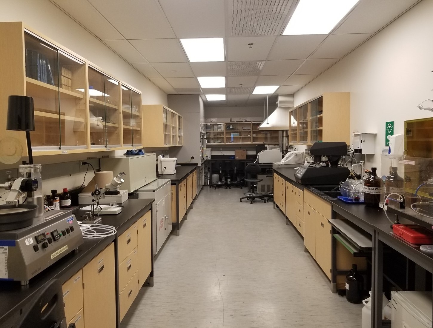 Lab benches along two walls with various lab tools on the benches and cabinets above